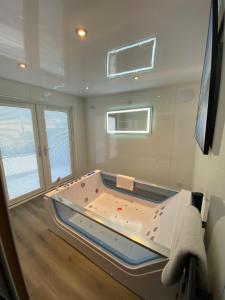 um quarto com uma grande banheira num quarto em Highland Stays - Ben View Room & Jacuzzi Bath em Fort William