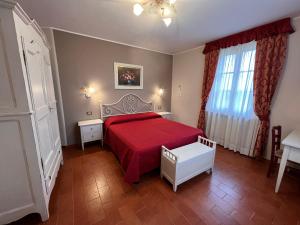 B&B Casale Virgili في سيينا: غرفة نوم بسرير احمر ونافذة