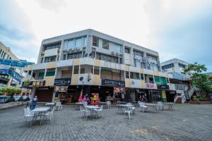 a building with tables and chairs in front of it at AC Residence - Behind Cititel Hotel in Kota Kinabalu