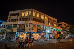 a building with people sitting at tables in front of it at AC Residence - Behind Cititel Hotel in Kota Kinabalu