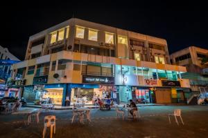 a building with tables and chairs in front of it at night at AC Residence - Behind Cititel Hotel in Kota Kinabalu