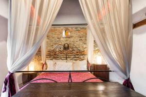 um quarto com uma cama com uma parede de pedra em Sambuca Home Loft em San Romano