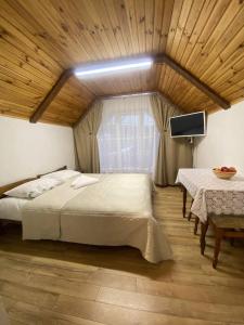 Schlafzimmer mit einem Bett, einem TV und einem Tisch in der Unterkunft Затишок в Карпатах 1 in Slawske