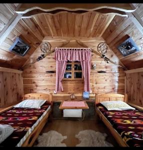 um quarto com duas camas num chalé de madeira em Etno smjestaj Bjelasica em Kolašin