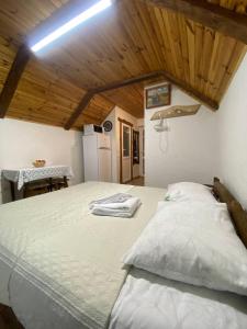 a large bed in a room with a wooden ceiling at Затишок в Карпатах 1 in Slavske