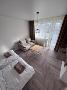 uma sala de estar com uma cama e um sofá em MOYA Apartmentai em Naujoji Akmenė