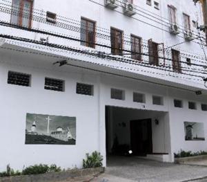 a large white building with a door and a balcony at Hotel Laundos in São Paulo