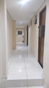 a hallway in a building with a white floor at Hotel Progresso in Curitiba