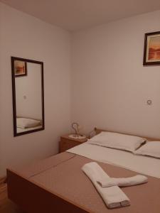 una camera con due letti e uno specchio a muro di Apartments Grozdana 4227 a Crikvenica