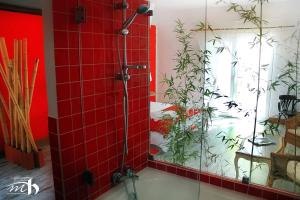 uma casa de banho com um chuveiro com paredes em azulejos vermelhos em Monte do Mato dos Homens na Vidigueira
