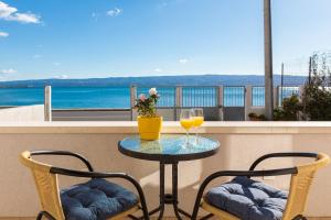 a table with two glasses of wine on a balcony at Sea La Vie in Dugi Rat