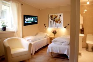 a hotel room with two beds and a chair at Tynset Rom & Camping in Tynset