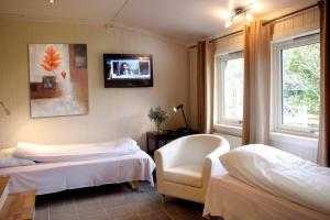 a bedroom with two beds and a tv on the wall at Tynset Rom & Camping in Tynset