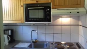 a kitchen with a sink and a microwave at Appartement 24 Les Chalets du Jardin Alpin in La Salle Les Alpes +13 photos