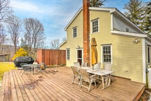 Charming Sharon Dwelling with Deck and Fire Pit! في Sharon: سطح خشبي مع طاولة وكراسي ومنزل