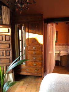 1 dormitorio con tocador de madera y cama en TERRACEA, en Hoyos