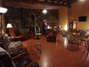 uma sala de estar com cadeiras e uma parede de pedra em Albergue San Lázaro em Sarria