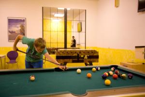 a young man playing pool in a room at Hotel Hohe Tauern in Matrei in Osttirol