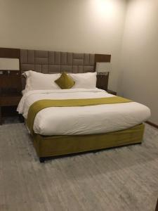 منتجع وشاليهات وسام بارك Wesam Park Residences & Chalets في الطائف: غرفة نوم بسرير كبير مع لوح رأس خشبي +25 صورة