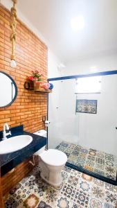 een badkamer met een toilet, een wastafel en een douche bij Pousada Camping dos Ypês in Guapimirim