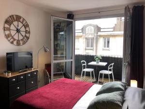 a bedroom with a bed and a balcony with a table at Studio avec balcon & parking gratuit - Tours Gare in Tours