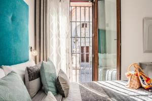 a bedroom with a bed with pillows and a window at Amphora Alojamiento Ecija in Écija