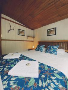 a bedroom with a large bed with a blue blanket at Hotel El Abrazo del Arbol in Mindo
