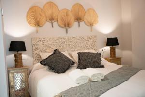 1 dormitorio con 1 cama con 2 almohadas y 2 lámparas en Apartamento Alma Sevilla, en Sevilla