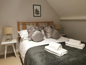 a bedroom with a bed with towels on it at Blakeney House in Blakeney