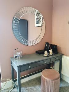 a dressing table with a mirror and a stool at Blakeney House in Blakeney