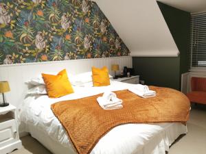 a bedroom with a bed with towels on it at Blakeney House in Blakeney