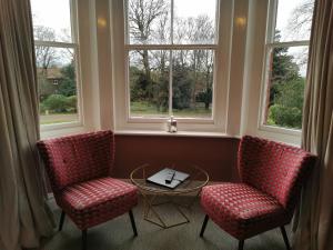 two chairs and a table in a room with windows at Blakeney House in Blakeney