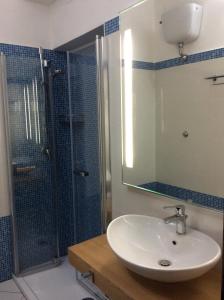 a bathroom with a sink and a shower with a mirror at Hotel Mediterraneo in Santa Maria Navarrese