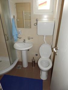 a small bathroom with a toilet and a sink at Apartments Center KG in Kragujevac
