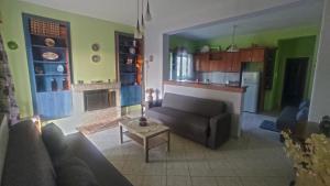 Il comprend un salon avec un canapé et une cuisine. dans l'établissement Giorgos house, à Dhounaíika