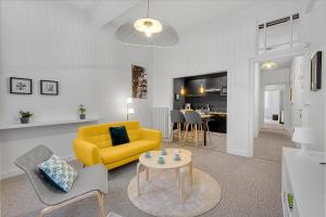 a living room with a yellow couch and a table at LE PLAISANCIER - T3 entièrement rénové de 60m3 in Toulouse