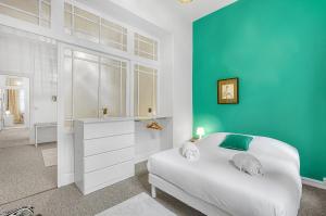 a bedroom with a white bed and a blue wall at LE PLAISANCIER - T3 entièrement rénové de 60m3 in Toulouse