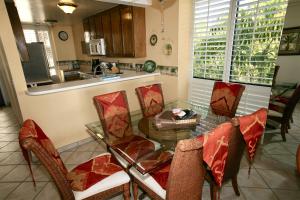 een eetkamer met een glazen tafel en stoelen bij D2 - Breakwater Bungalow in Oceanside