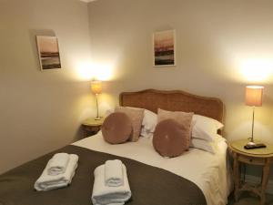 a bedroom with a bed with two towels on it at Blakeney House in Blakeney