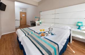 pokój hotelowy z łóżkiem z tacą z jedzeniem w obiekcie Estudios Aránzazu w mieście Santander