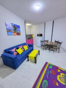 uma sala de estar com um sofá azul e uma mesa em Apartment Place of Dreams near the sea RedSeaLine em Hurghada