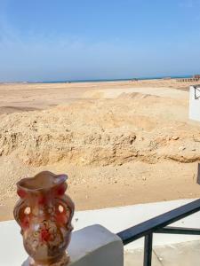 un jarrón sentado en una mesa junto a una playa en Apartment Place of Dreams near the sea RedSeaLine en Hurghada