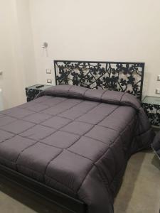 um quarto com uma cama grande e um edredão roxo em Agriturismo B&B Dal Professore em Sicignano degli Alburni