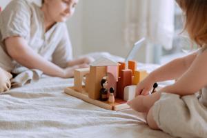 a woman and child playing with a toy on a bed at The Diplomat Hotel in Sliema