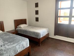 um quarto com duas camas e uma janela em Depametepec55 em Toluca