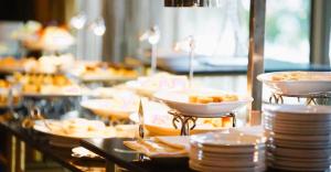 a buffet line with plates and bowls of food at The Diplomat Hotel in Sliema