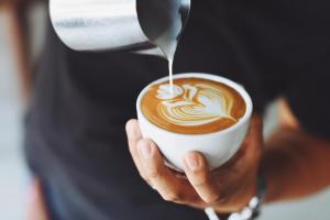 a person is holding a cup of coffee at The Diplomat Hotel in Sliema