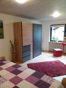 ein Schlafzimmer mit einem Bett und einer Kommode in der Unterkunft Haus Saufelsen in Ludwigswinkel