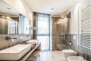 bagno con lavandino, vasca e servizi igienici di Erika Suites & Lofts a Stanga