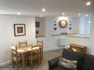 a kitchen and living room with a table and chairs at Crossways Corner Cottage in Gunnislake
